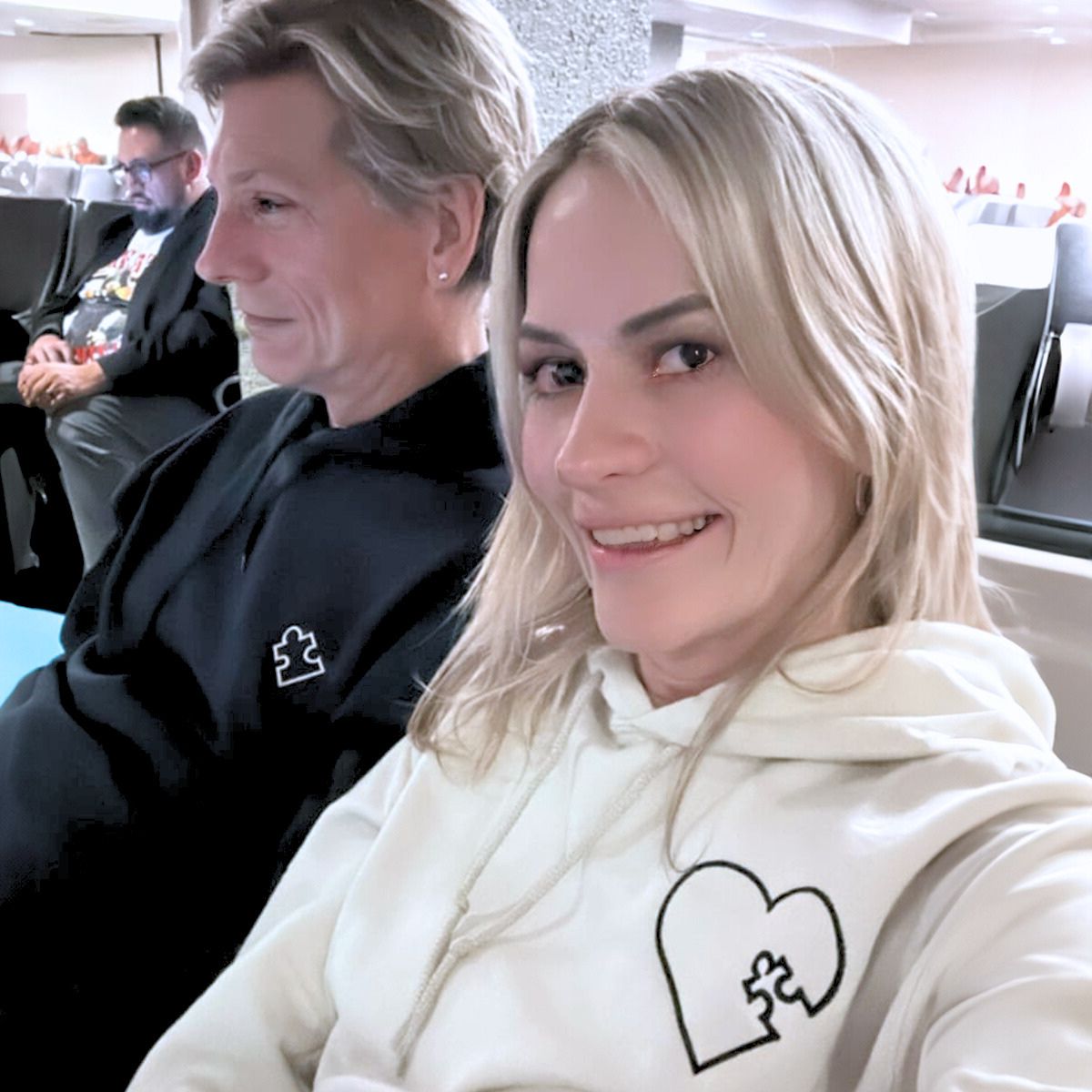 Romantic couple wearing black and white Embroly hoodies with puzzle heart embroidery, symbolizing their connection.