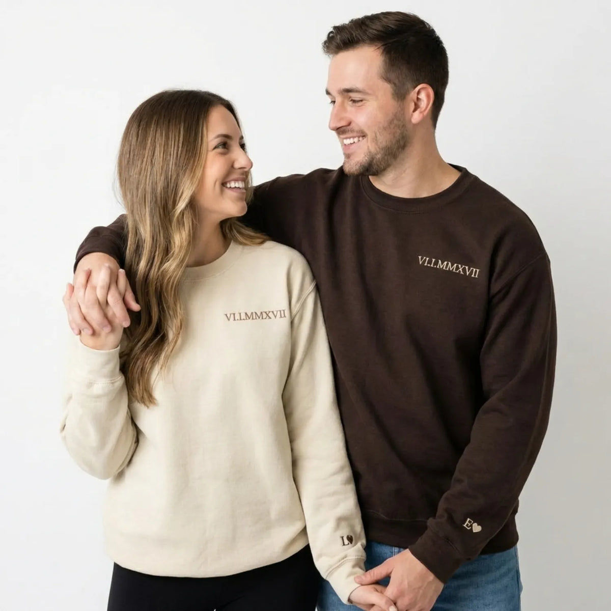Man and woman wearing matching sweatshirts with roman numeral sweatshirt