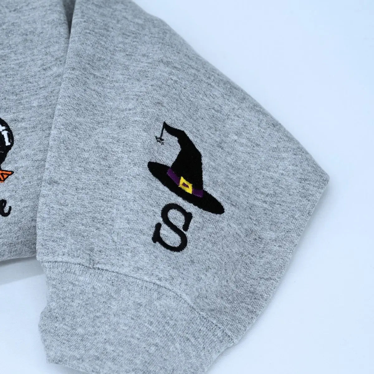 Funny spooky goose embroidered Halloween sweatshirt on flatlay with fall decorations