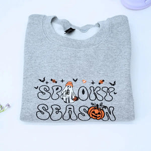 Custom embroidered spooky season sweatshirt with ghost, pumpkin and bat icons on sleeve