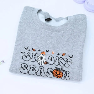 Custom embroidered spooky season sweatshirt with ghost, pumpkin and bat icons on sleeve