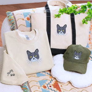 Cat-themed gift set including sweatshirt, tote bag, and hat displayed on a cozy background