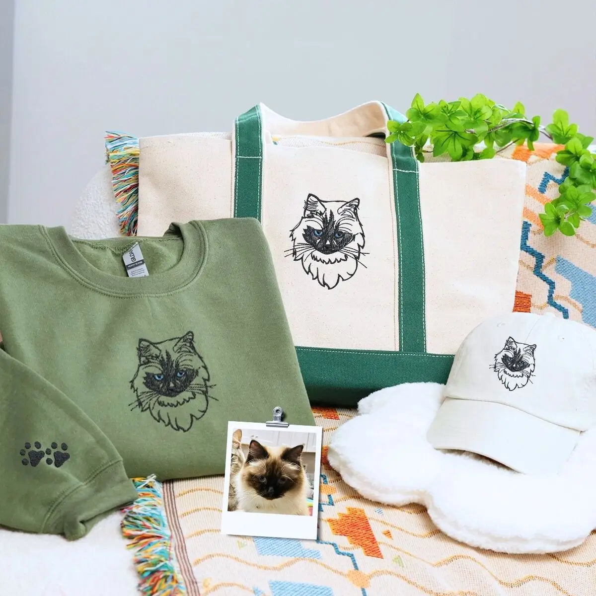 Cat-themed gift set including sweatshirt, tote bag, and hat displayed on a cozy background