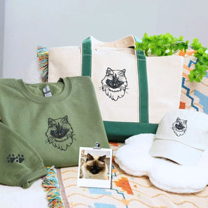 Cat-themed gift set including sweatshirt, tote bag, and hat displayed on a cozy background